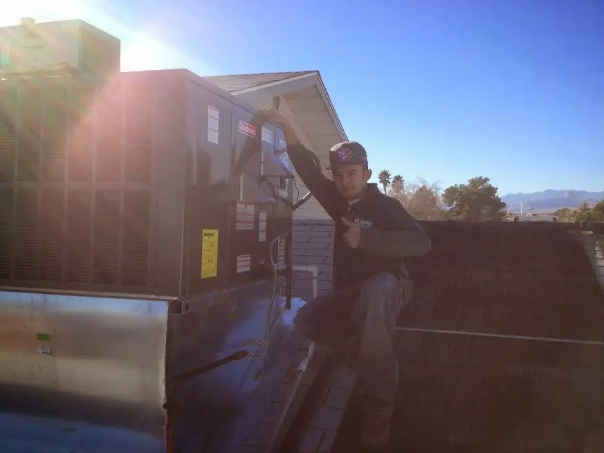 HVAC technician performing Heat Pump Repair on a rooftop unit in Westport